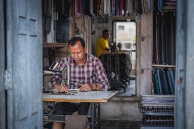Katmandu, Nepal 'de yerel bir gösteride dikiş makinesi üzerinde çalışan bir adam.