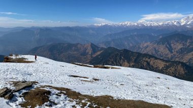 Bir kış günü karla kaplı bir dağın tepesinden manzaralı bir manzara.