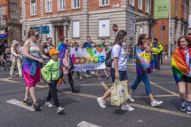 İrlanda, Dublin 'deki Onur Festivali' nde gökkuşağı bayraklarıyla yürüyen bir grup insan