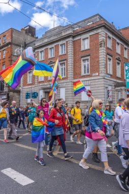 İrlanda, Dublin 'deki Onur Festivali' nde gökkuşağı bayraklarıyla yürüyen bir grup insan