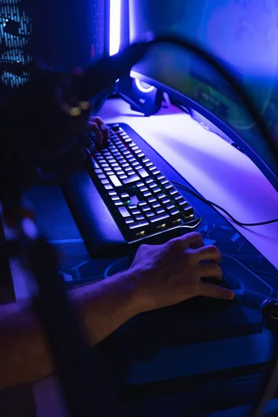 青い光の部屋でPc上でゲームをプレイマウスとキーボードの手の垂直ショット — ストック写真