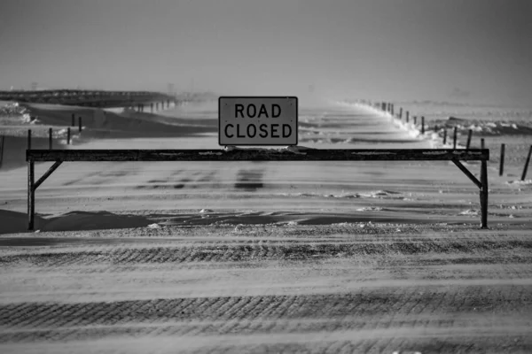 雪地里一根杆子上 道路封闭 标志的灰度 — 图库照片