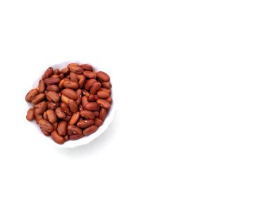 Beyaz arka planda izole edilmiş plastik kaseye konmuş yiyecek taneleri