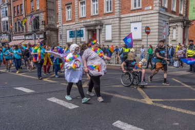 İrlanda, Dublin 'deki Onur Festivali' nde gökkuşağı bayraklarıyla yürüyen bir grup insan