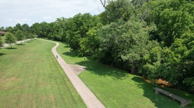 Uzun bir yürüyüş yolu olan yeşil çayır parkının hava görüntüsü.