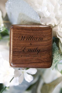 William ve Emily için oyulmuş ahşap bir alyans kutusunun dikey görüntüsü.