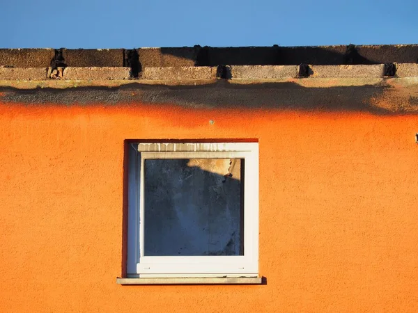 Nahaufnahme Eines Kleinen Fensters Der Gipsorangefarbenen Wand — Stockfoto
