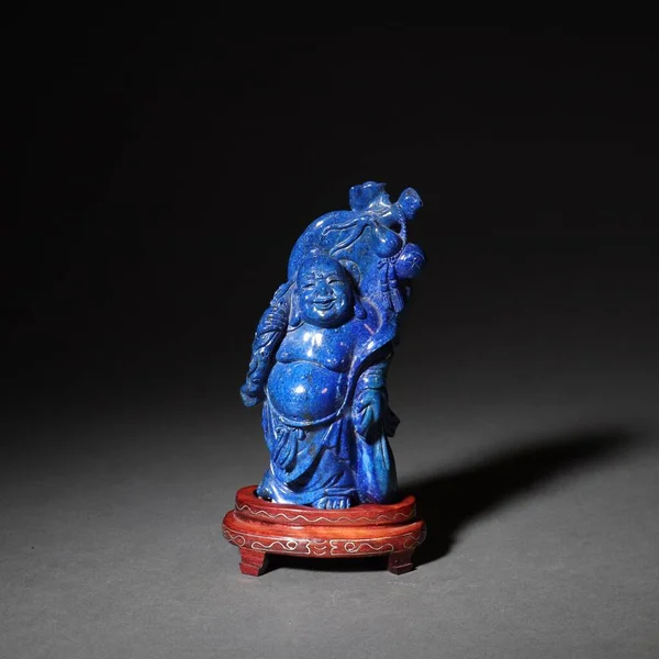 A traditional Chinese lapis lazuli sculpture with a dark background