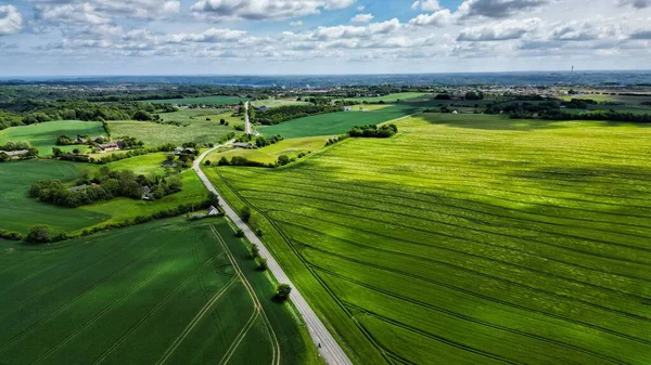 青い空と緑豊かな緑のフィールドを介して高速道路の空中パノラマビュー — ストック写真