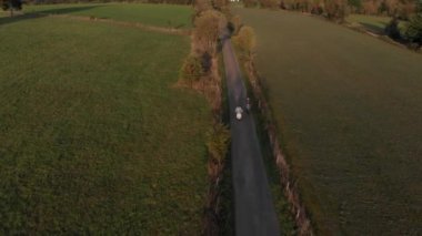 Gün batımında Vespas 'taki bir tarlada bir yolun havadan görüntüsü.