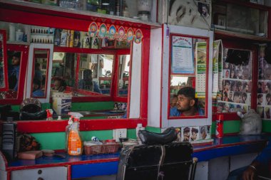 Nepal Katmandu 'daki berber dükkanında bir berber oturuyor.