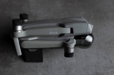 Katlanmış taşınabilir kuadkopter DJI Air 2S İHA 'sı modern gri desenli masa tezgahına karşıdır.