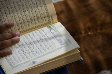 Kutsal Kuran okuyan biri.