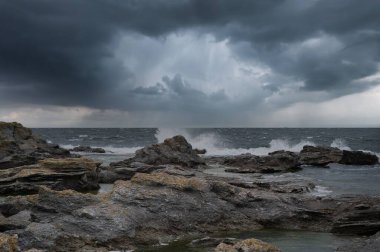 Bulutlu bir günde kayalık bir deniz kıyısı