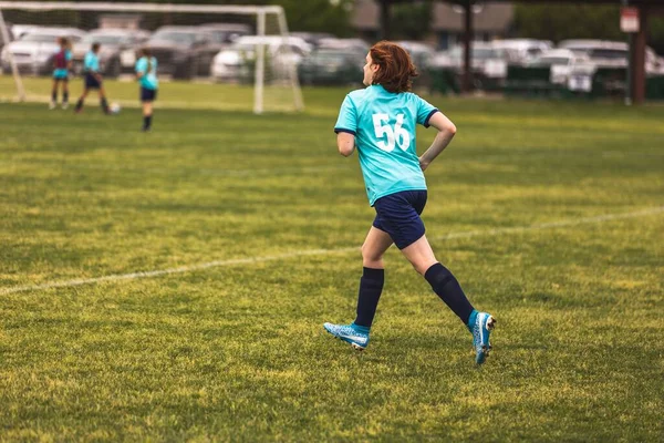 Genç Bir Kız Futbol Oynarken Mavi Üniformalı Koşuyor — Stok fotoğraf