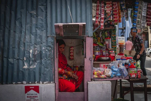 尼泊尔首都加德满都 一位女士坐在店面后面 敞开着一扇小门 — 图库照片