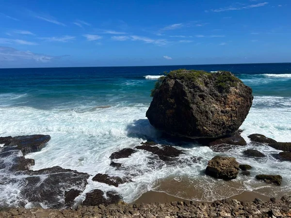 海浪在蓝天背景的海岸附近冲撞形成了一个岩层 — 图库照片