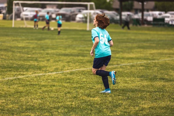 Genç Bir Kız Futbol Oynarken Mavi Üniformalı Koşuyor — Stok fotoğraf