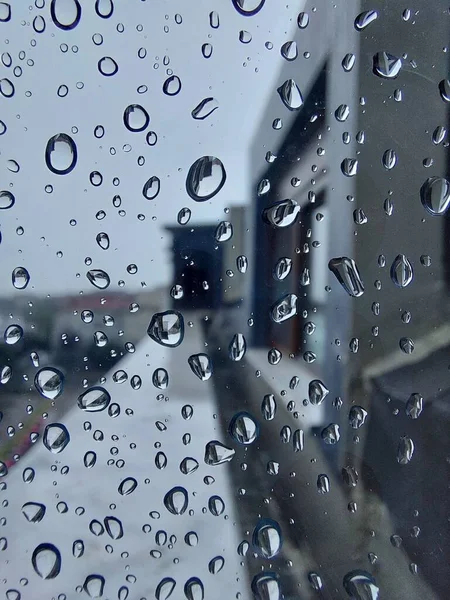 Pionowe Zbliżenie Szyby Okien Pokryte Kroplami Deszczu Rozmytym Widokiem Tle — Zdjęcie stockowe