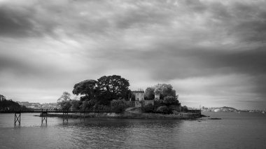 Kasvetli bir günde, gölü ve köprüsü olan gri bir manzara.