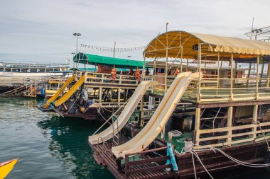 Tayland ve Güneydoğu Asya 'daki bir rıhtımda kıç tarafında su kaydırağı olan bir tur ya da tekne.