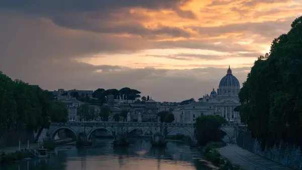 サンタンジェロ橋とサンピエトロ大聖堂は日没時に曇った空に対して — ストック写真