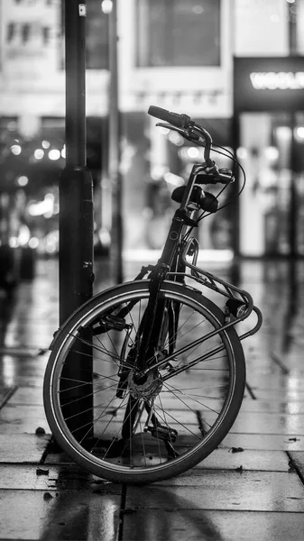 Bir sütunun yanına park edilmiş gri bir bisiklet lekesi.