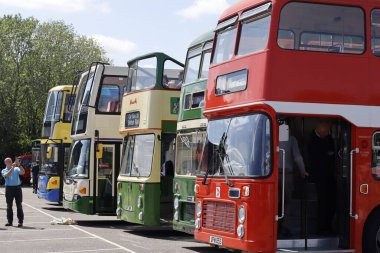 Dereham tren istasyonuna park edilmiş beş renkli çift katlı otobüs, Breckland, İngiltere