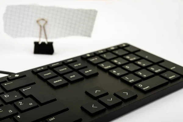 黒いコンピュータのキーボードと白い背景に隔離された紙クリップの一部 — ストック写真