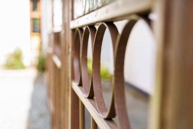 A closeup of an iron fence on a blurred background