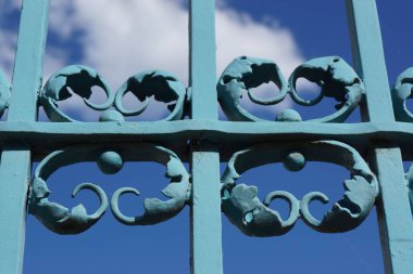 Bad Homburg kalesinde mavi gökyüzüne karşı dövülmüş demir kapının detayları. Genellikle üzerini boyadığım bir sanat eseri. Güzel bir renk ve gölge oyunu.