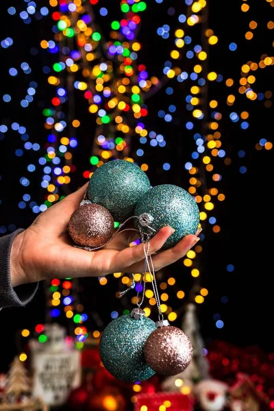 Uma Mão Humana Segurando Bolas Natal Contra Bokeh Luzes Fundo — Fotografia de Stock