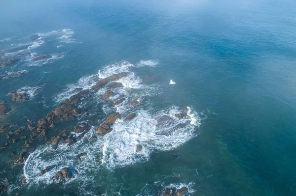 在多雾天气下俯瞰一片片岩石海岸线的无人驾驶飞机图像 — 图库照片