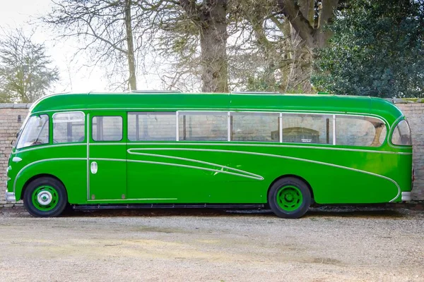 Яскраво Зелений Автобус Припаркований Перед Цегляним Парканом — стокове фото