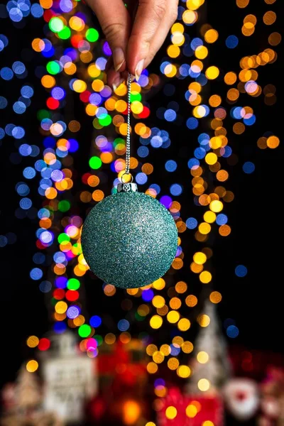 Uma Mão Humana Segurando Bola Natal Contra Bokeh Luzes Fundo — Fotografia de Stock