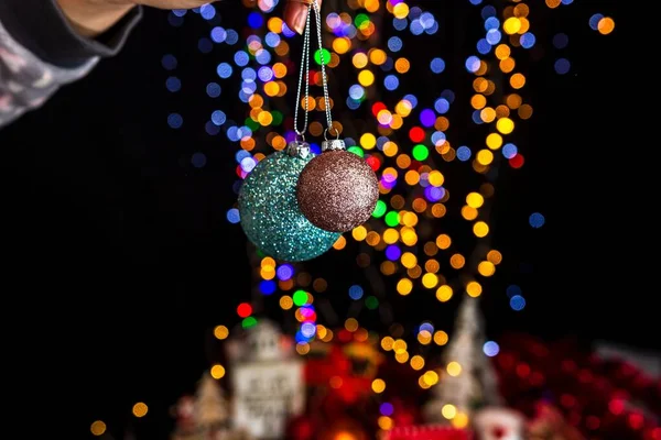 Een Menselijke Hand Houden Kerstballen Tegen Bokeh Lichten Achtergrond — Stockfoto