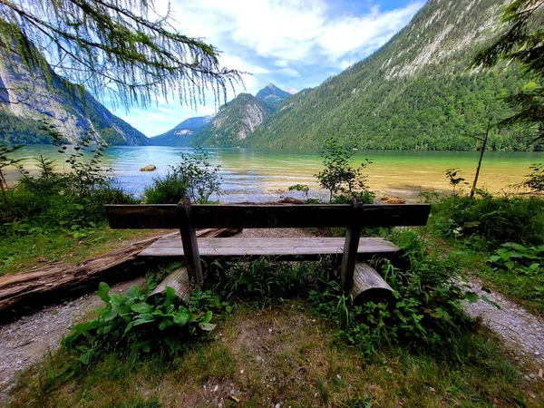 一条木制长椅 后面有湖泊和山脉 — 图库照片