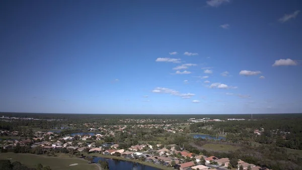 Tiro Aéreo Uma Cidade Florestada Lago Sob Céu Azul — Fotografia de Stock