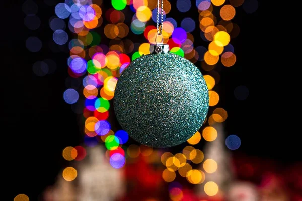 Een Hangende Groene Kerstbal Tegen Bokeh Lichten Achtergrond — Stockfoto
