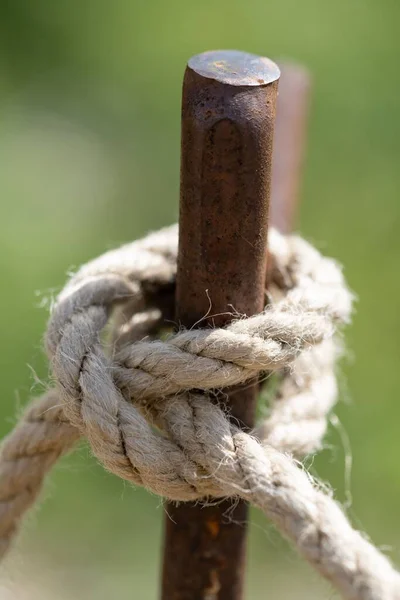 背景がぼやけている金属製の棒に結び付けられたロープの結び目 — ストック写真