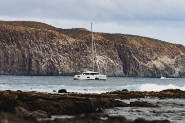 Kayalık denizde beyaz bir tekne