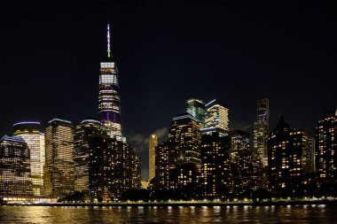 Gökdelenlerin güzel bir gece manzarası. Göllü bir şehirde birçok ışık var.