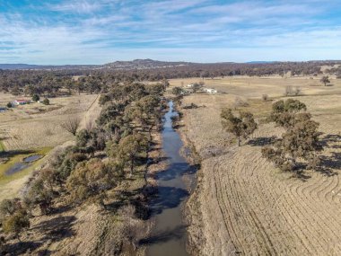 Diepwater, NSW, Avustralya 'da gün ışığında dar bir nehirle doğal manzaralara bakan bir dron görüntüsü.