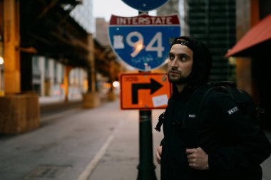 Chicago, Illinois 'de bir sokak tabelasının yanında poz veren yakışıklı beyaz bir adam.