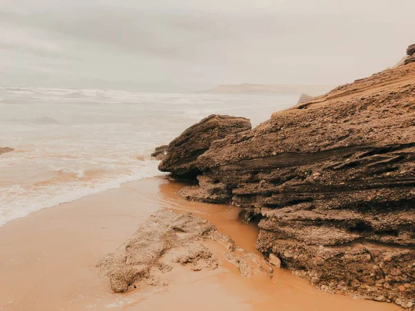 Rotsachtige Kliffen Een Strand Boven Een Achtergrond Van Een Bewolkte — Stockfoto