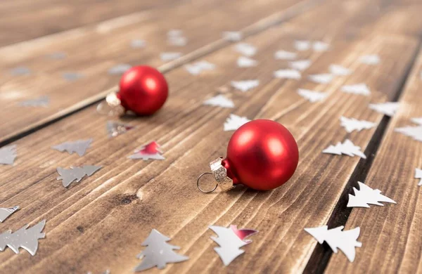 Κόκκινες Χριστουγεννιάτικες Μπάλες Ασημένια Κομφετί Ξύλινο Τραπέζι — Φωτογραφία Αρχείου