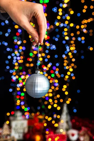 Eine Menschliche Hand Hält Weihnachtskugel Vor Bokeh Licht Hintergrund — Stockfoto