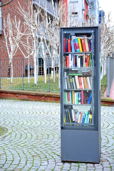 ドイツのフランクフルトの路上で本で満たされた公共の本棚の垂直ショット — ストック写真