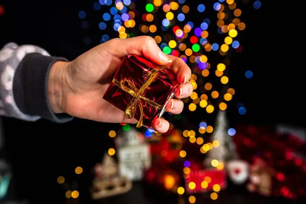 Uma Mão Humana Segurando Decoração Natal Contra Bokeh Luzes Fundo — Fotografia de Stock