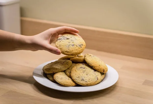 Closeup Female Hand Taking Chocolate Chip Cookie Plate Wooden Table — Stock Photo, Image